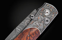 Damascus steel folding knife with engraved two quails and copper accents on dark metal, rich wood handle, side view