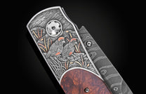 Hand-engraved folding knife with two quails and copper accents, by B12, featuring textured silver scales and rich wood handle, side view.