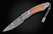 Folding knife with wooden handle and decorative blade on a black background