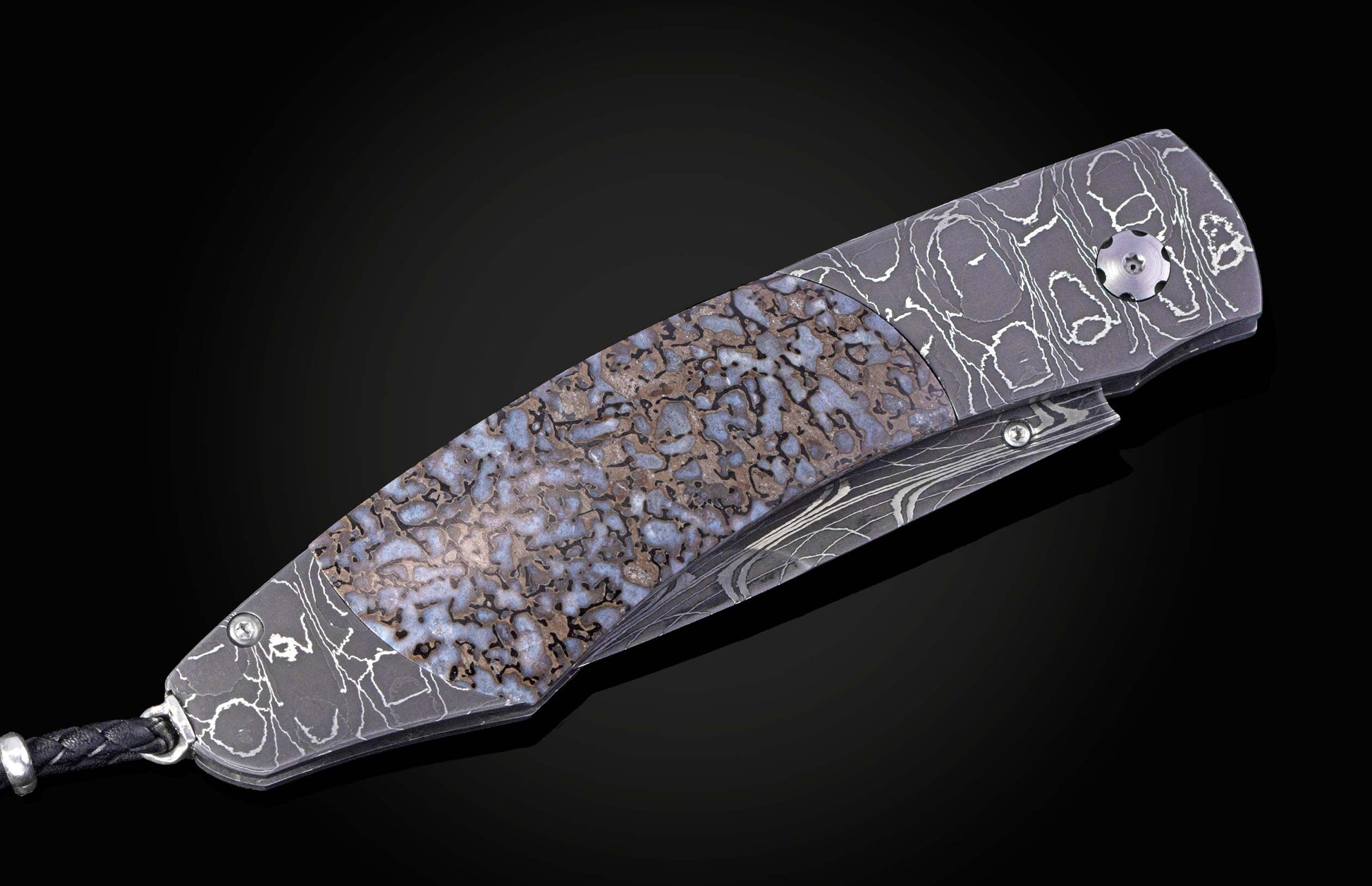 Decorative knife with damascus blade and dinosaur bone handle on a black background shown closed