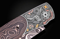 Western-style knife with engraved bull skull, snake, and compass design, featuring rose gold accents and layered wood handle, side view close-up