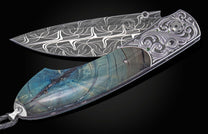 Decorative knife with damascus blade and fossilized woolly mammoth tusk scales on a black background