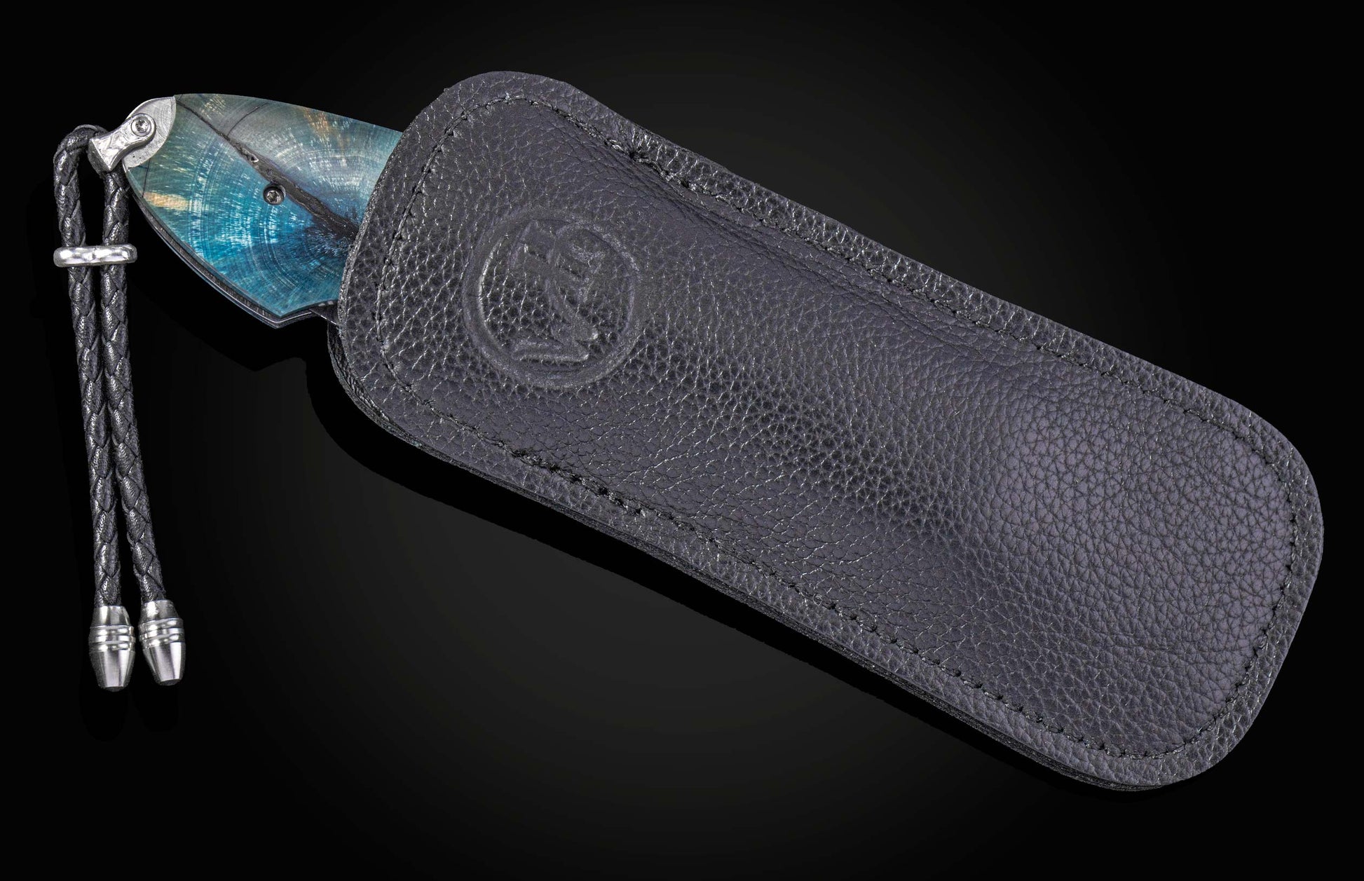 Decorative knife with damascus blade and fossilized woolly mammoth tusk scales on a black background