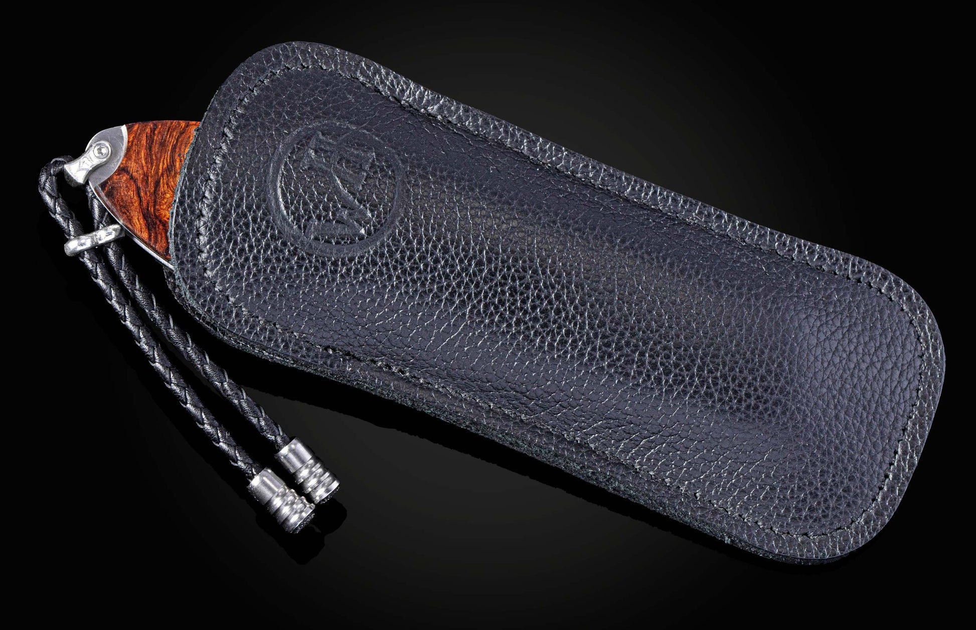 Folding knife with Damascus steel blade , hand engraving, and desert ironwood handle on a black background