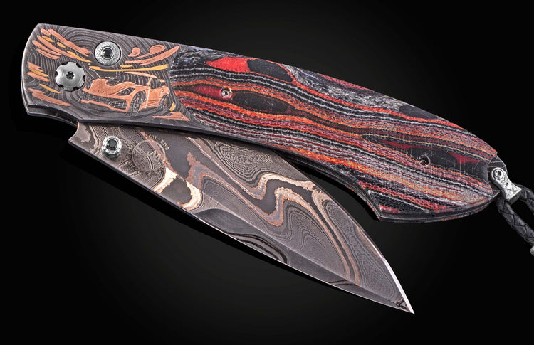 Luxury folding knife with damascus steel blade and red-black striped handle, featuring engraved sports car design on frame, side view