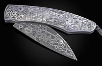 Engraved folding knife featuring Route 66 anniversary artwork on a silver handle, with a Damascus blade and blue gems.