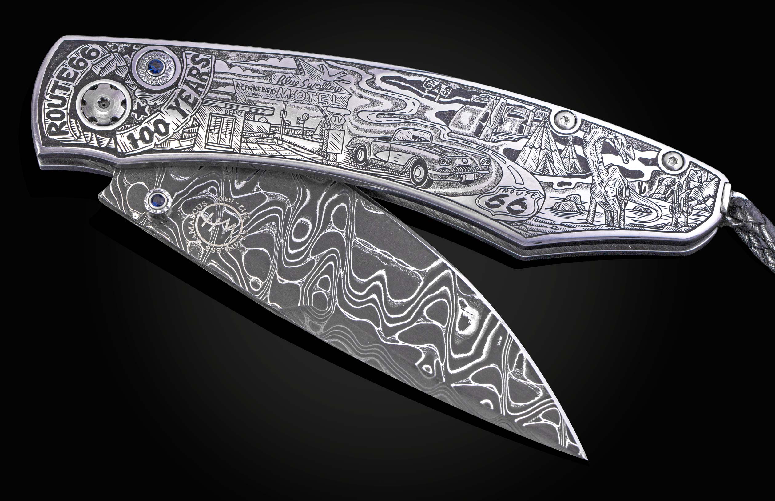 Engraved folding knife featuring Route 66 anniversary artwork on a silver handle, with a Damascus blade and blue gems.