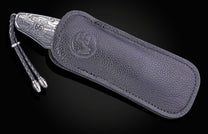 Engraved silver-tone knife with "Santa Monica", "Stop 66" and pier details, partially in a dark pebbled leather sheath with an embossed logo and braided lanyard.