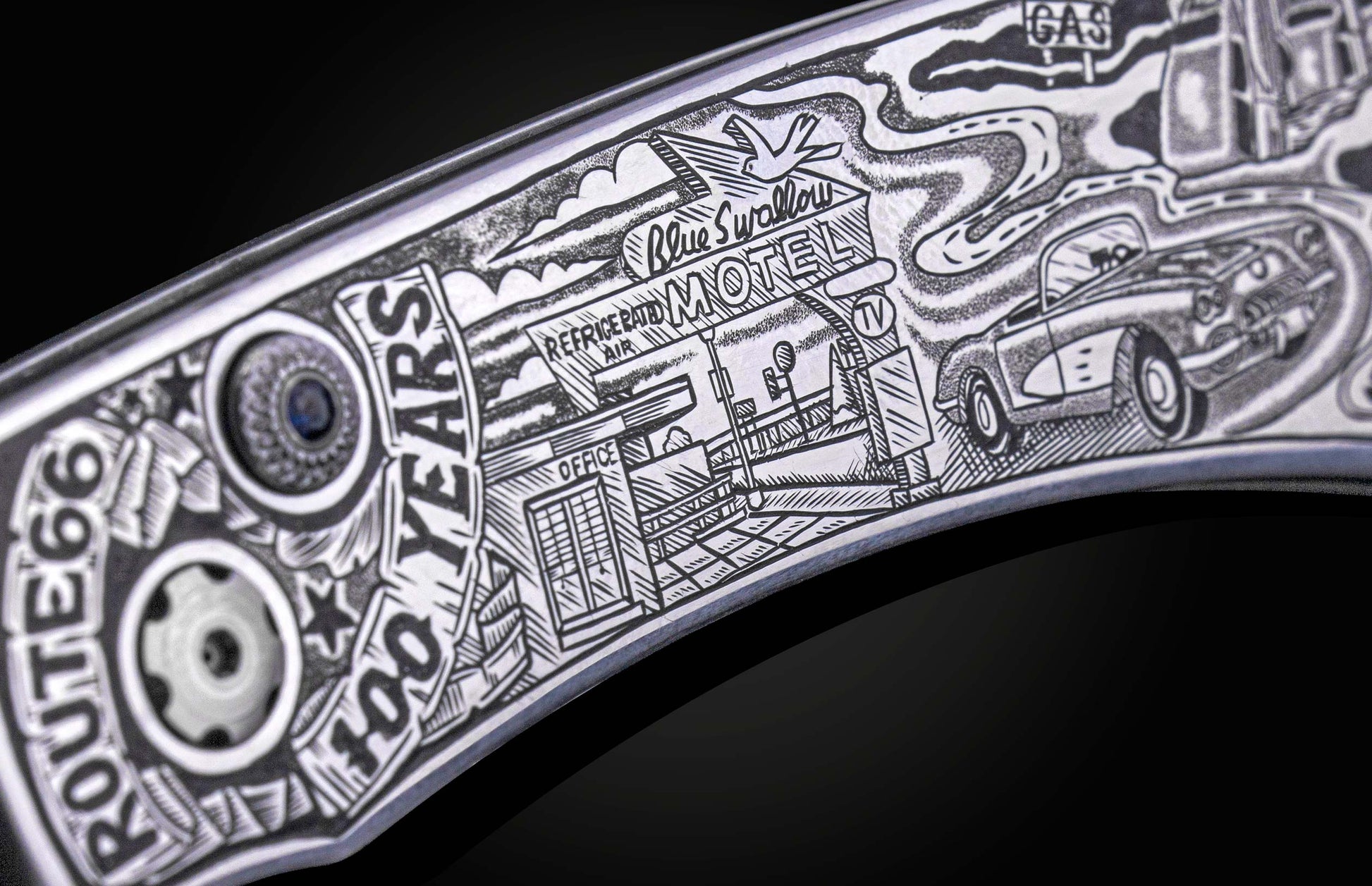 Metal knife with detailed engraved artwork depicting a Route 66 scene, including a motel, vintage car, and "100 YEARS" text.