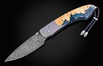 William Henry knife with a damascus steel blade and shockwood handle on a black background