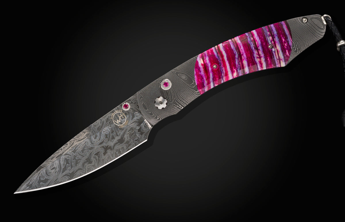 Damascus folding knife by B12 with vibrant pink stabilized wood handle and ruby inlays.