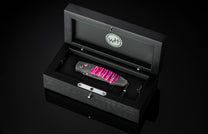 Luxury folding knife with vibrant pink and purple resin inlays by B12 Hope, displayed in a sleek black presentation case.