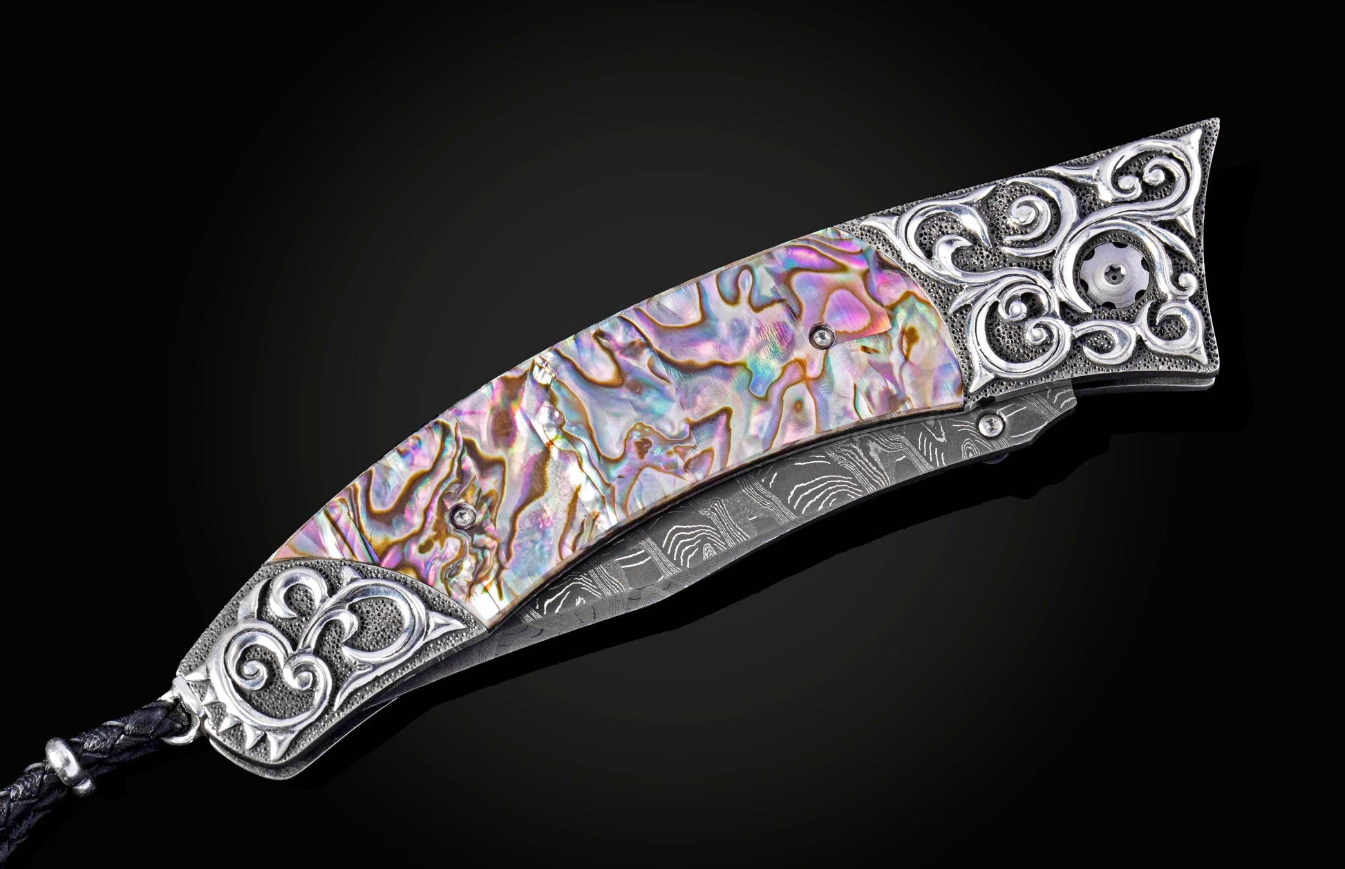 Decorative knife with abalone shell handle on a black background
