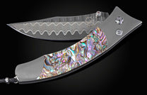 Foldable knife with abalone shell handle on a black background