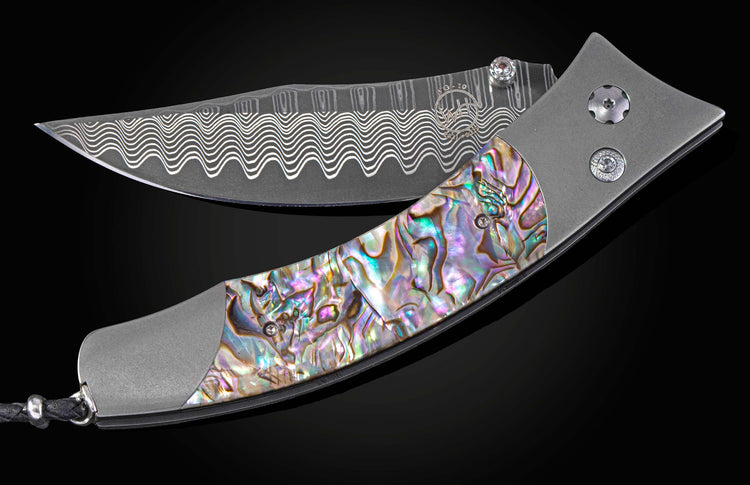 Foldable knife with abalone shell handle on a black background