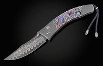 Foldable knife with abalone shell handle on a black background
