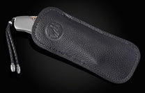 Foldable knife with abalone shell handle on a black background