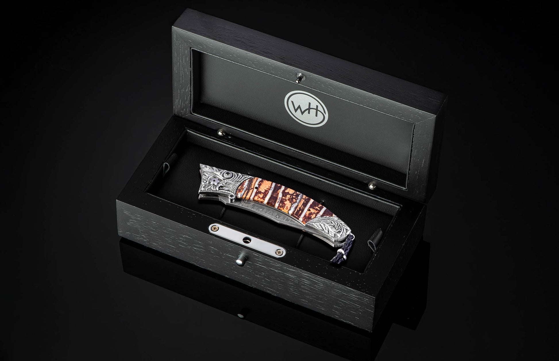 Black open box with a knife inside on a black background