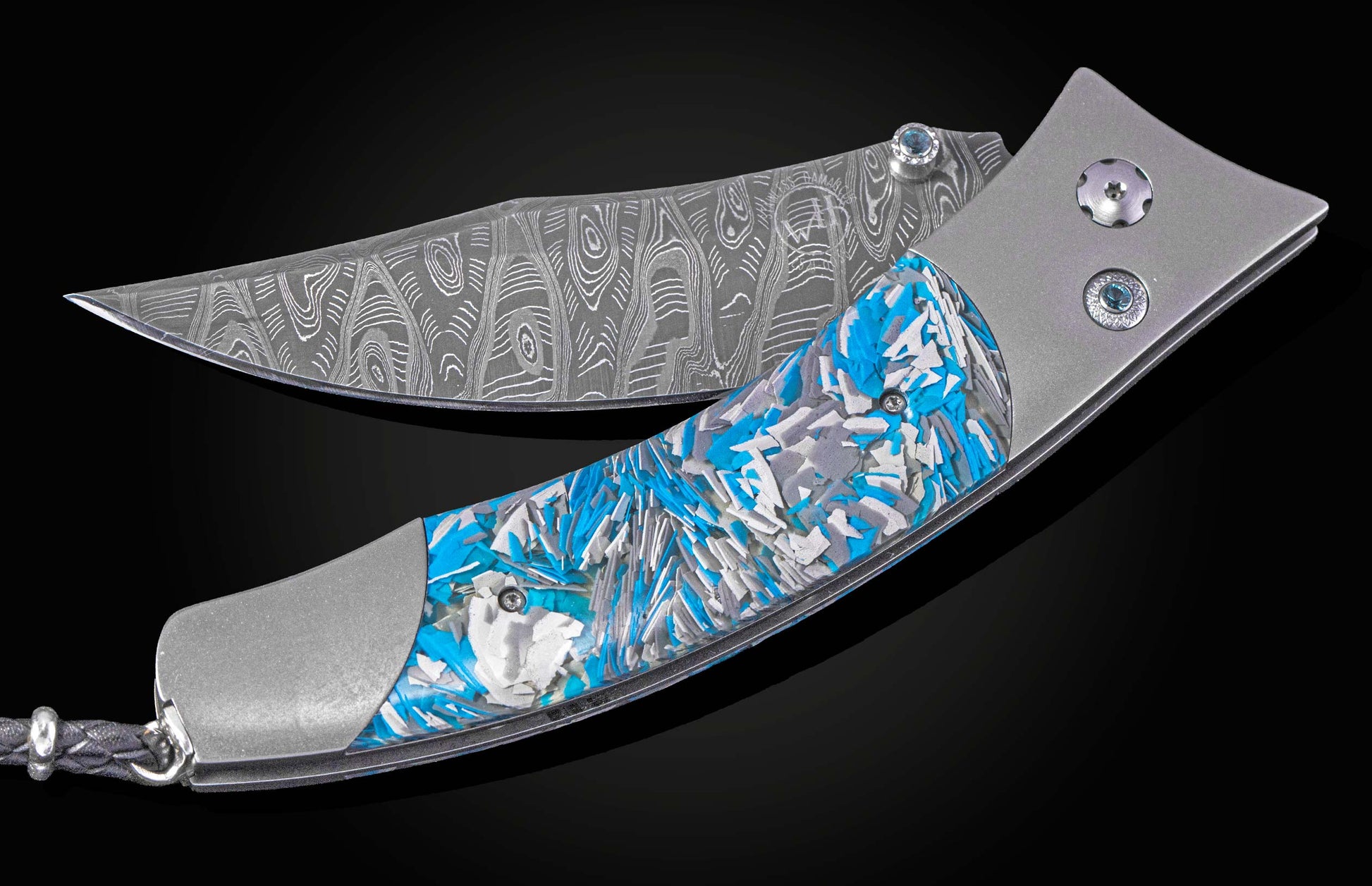 Folding knife with blue and silver patterned handle on a black background shown partially open