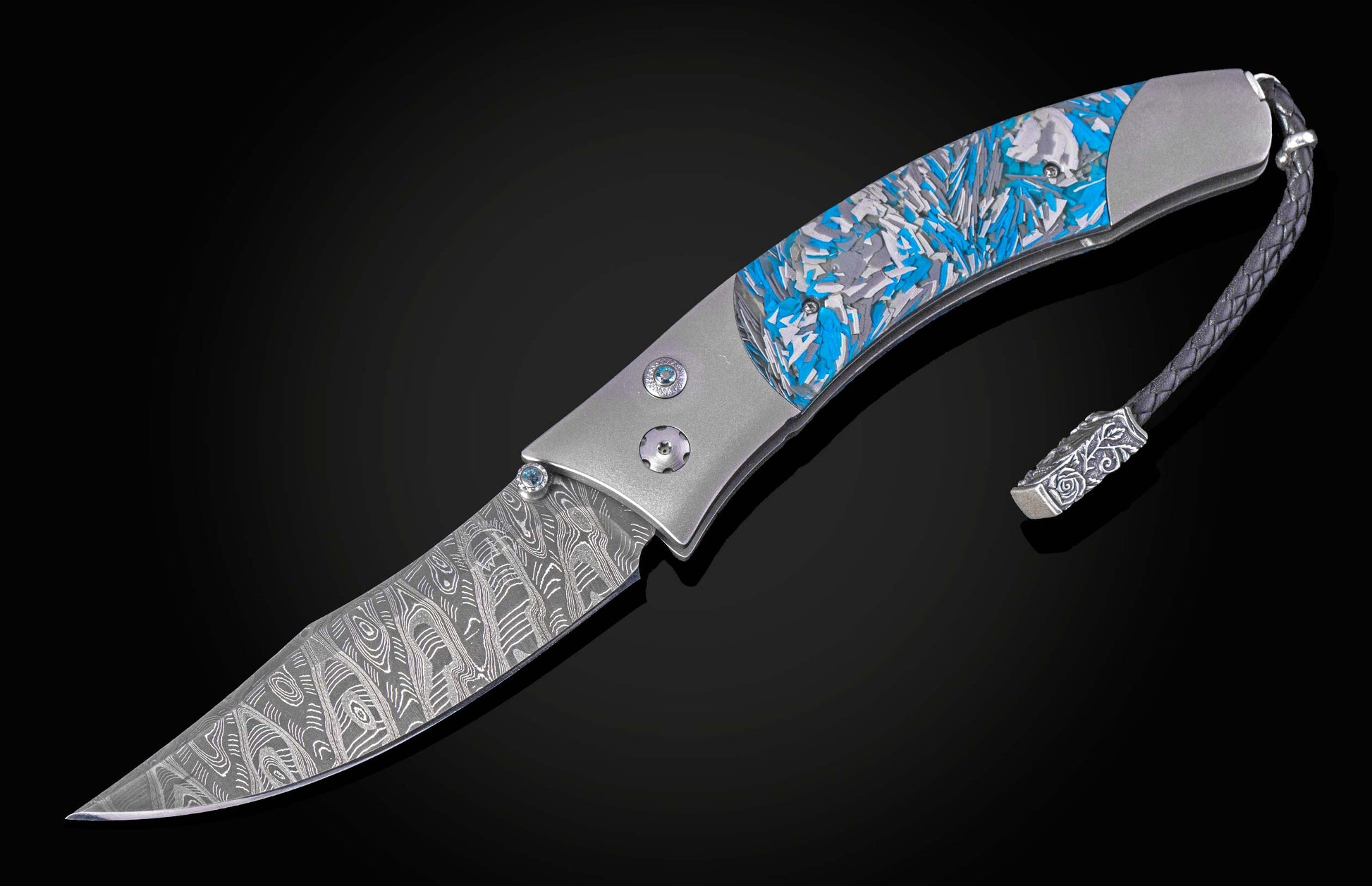 Folding knife with blue and silver patterned handle on a black background shown open