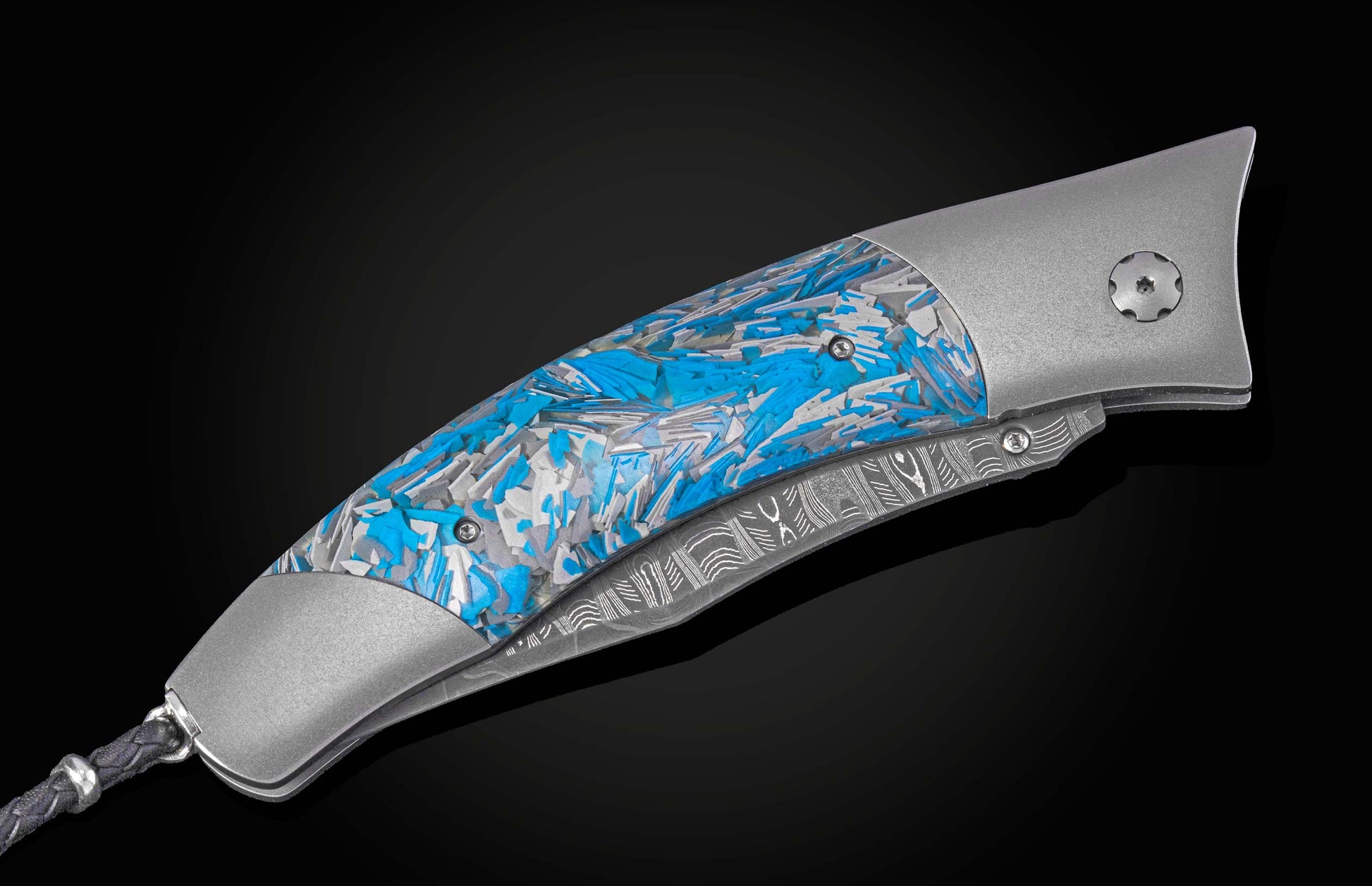Folding knife with blue and silver patterned handle on a black background shown closed