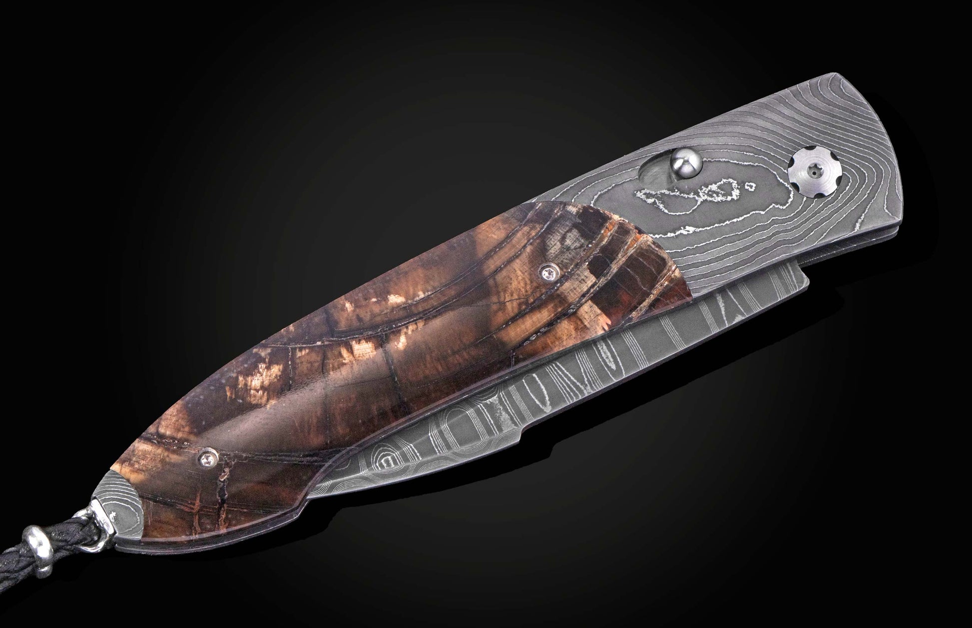 Damascus steel knife with fossil mammoth tusk scales. Displayed closed on a black background.