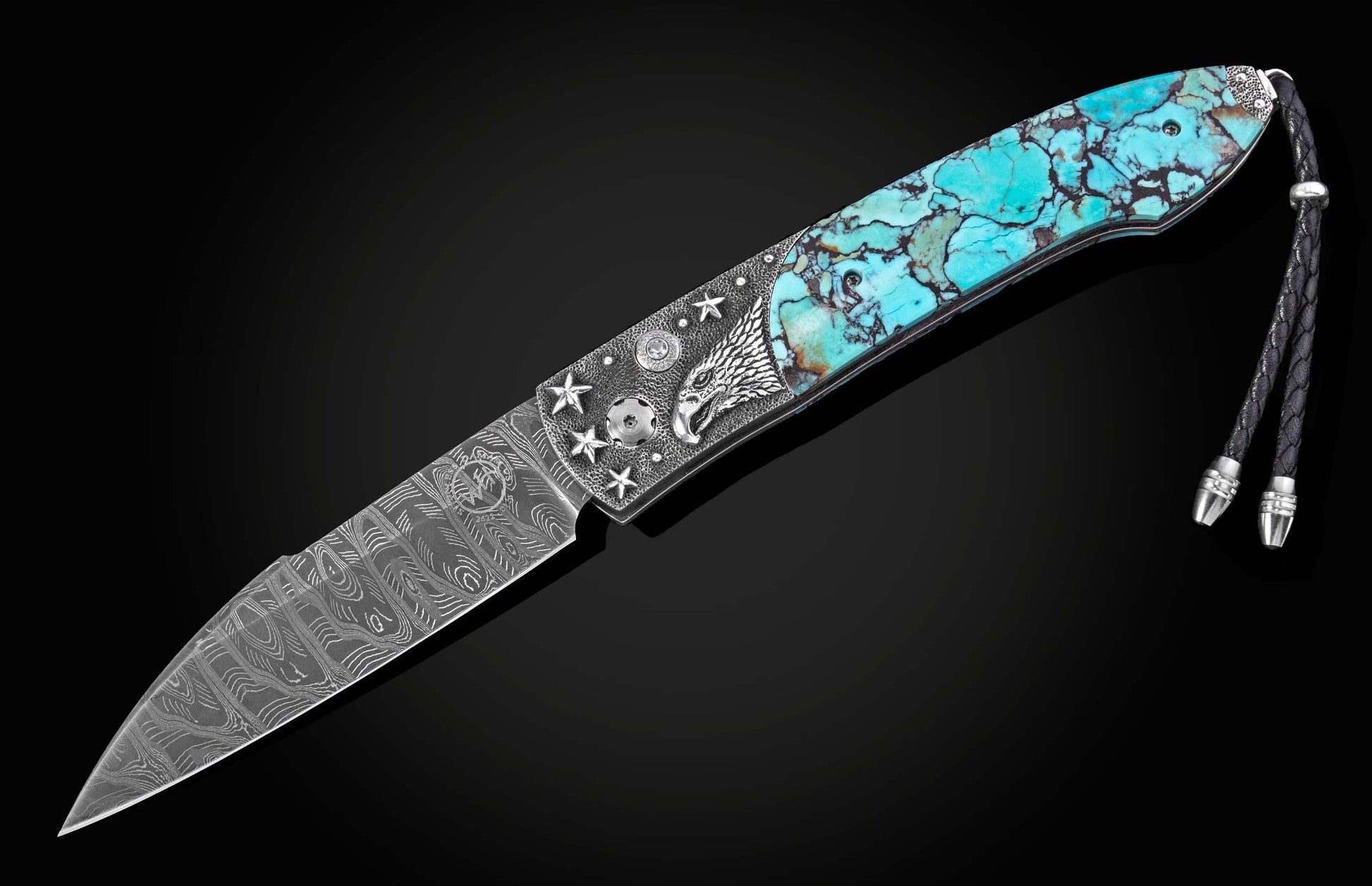 Angled automatic knife with a turquoise handle, silver screaming eagle, stars, and a Damascus blade with a braided black leather lanyard.