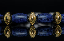 Bracelet featuring sodalite and gold beads with silver clasp