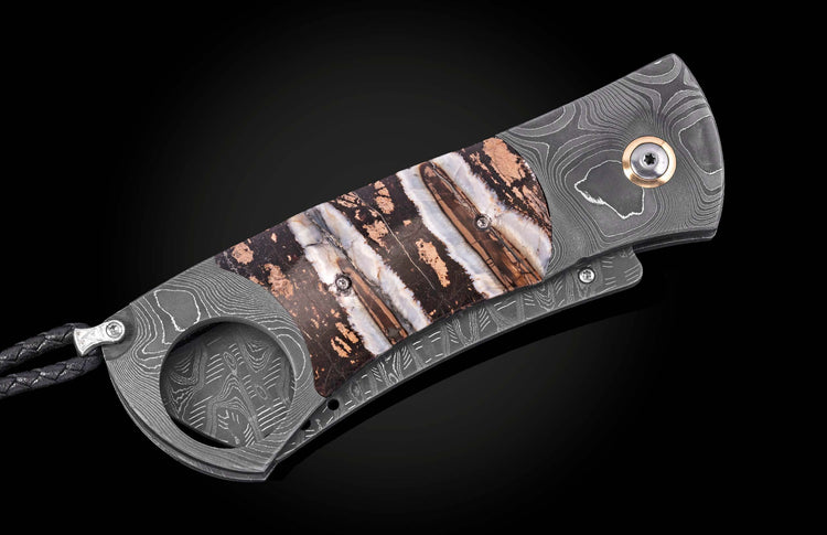 Luxury damascus steel cigar cutter with banded agate inlay, by CG1 Heirloom, featuring textured grip and braided leather lanyard, side view on black background