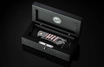 Luxury cigar cutter with damascus steel and wood inlay, by Willett, in black presentation box with engraved logo, top-down view