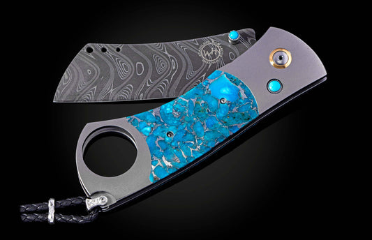 William Henry cigar cutter with turquoise handle and damascus blade on a dark background