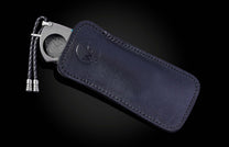 William Henry cigar cutter with turquoise handle and damascus blade on a dark background