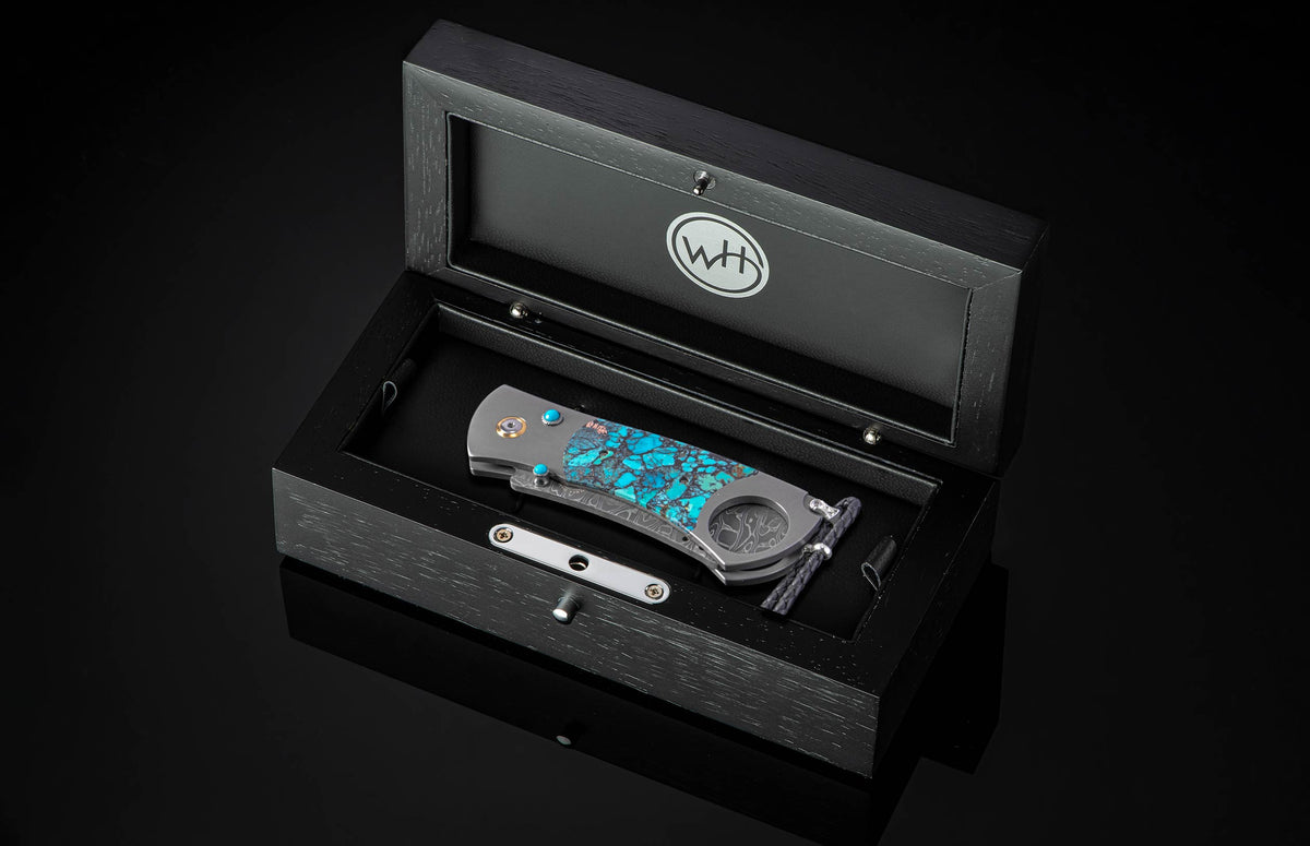 Turquoise inlay cigar cutter by W.H. in black wood box, polished metal accents, side view