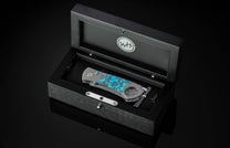 Turquoise inlay cigar cutter by W.H. in black wood box, polished metal accents, side view