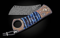 Luxury cigar cutter with damascus steel blade and blue resin inlay handle, featuring gold-toned floral engraving and braided lanyard, side view on black background