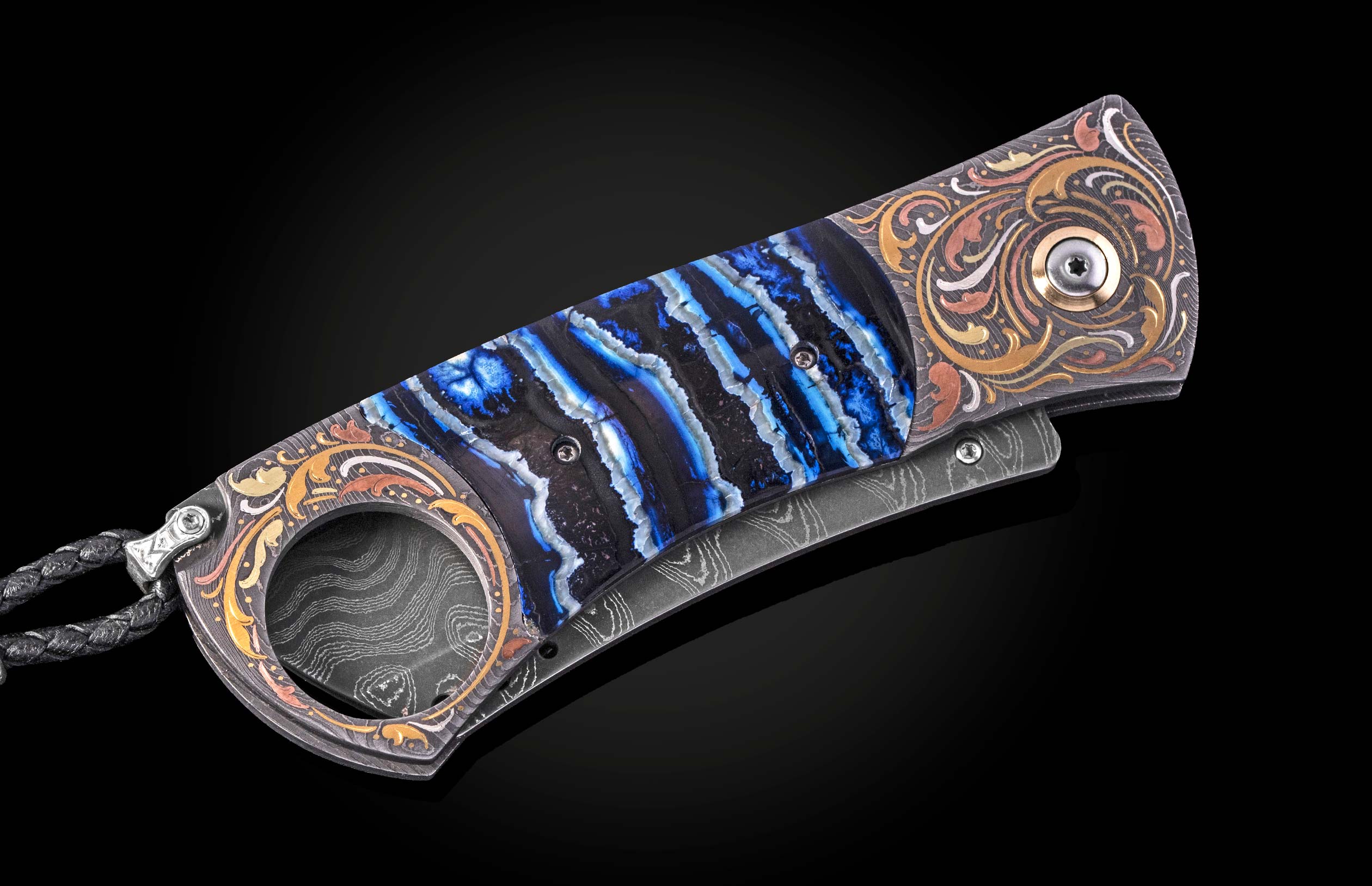 Luxury cigar cutter with blue agate inlay and ornate gold detailing, by CG1 SMOKE, side view on black background