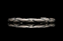 Silver bracelet with braided design on a black background