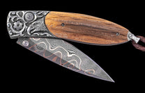 Decorative folding knife with wooden handle and damascus steel blade on a black background