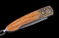 Folding knife with wooden handle and decorative blade on a black background