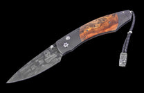 Intricate Damascus steel folding knife with reddish-brown wooden handle, engraved blade details, and a braided leather lanyard with an eagle-head bead.