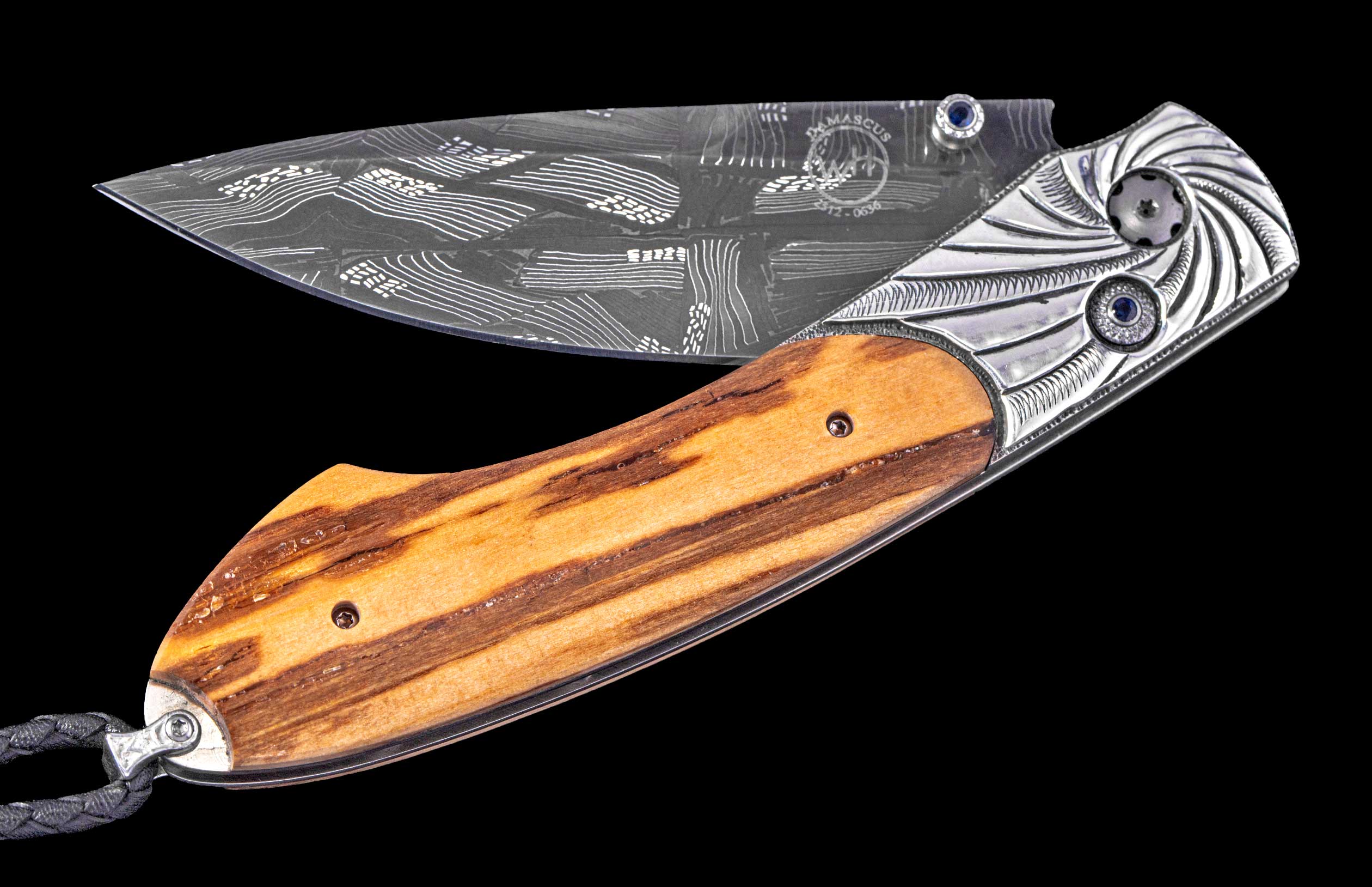 Open folding knife with a patterned Damascus steel blade, a striped light brown wood handle, engraved silver bolsters with blue accents, and a braided lanyard.