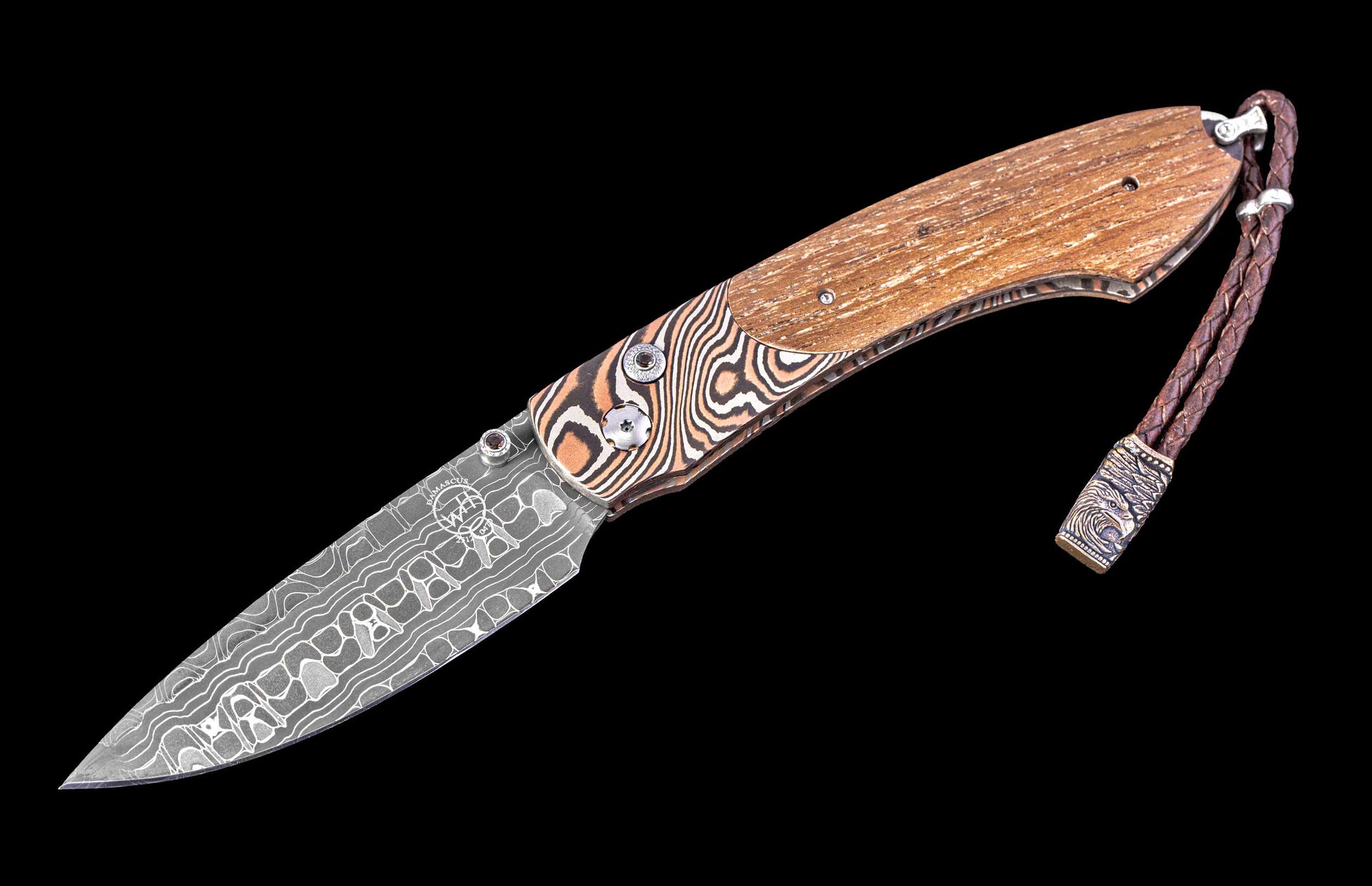 Foldable knife with wooden handle and patterned blade on a black background