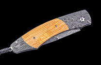 Folding knife with wooden handle and decorative blade on a black background