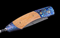 Folding knife with wooden handle and decorative blade on a black background