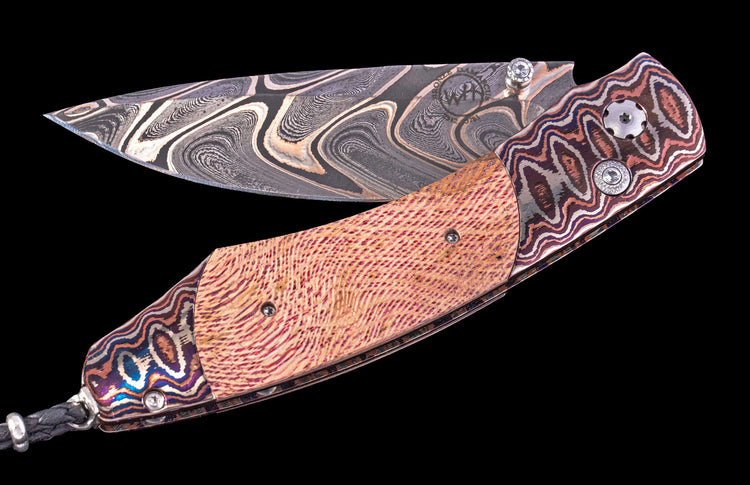 Decorative knife with a patterned blade and handle on a black background