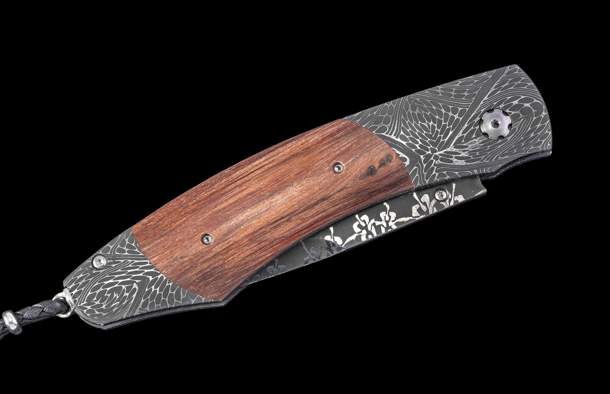 Folding knife with reddish-brown wooden handle, dark gray Damascus steel bolsters, and floral etching on the folded blade.