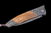 Decorative knife with wooden handle and Damascus steel blade on a black background