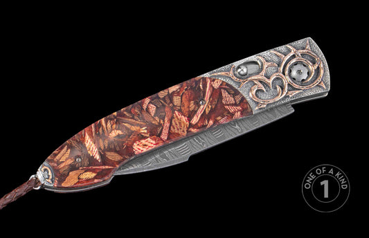 Decorative knife with hand carved design on a black background. Shown closed
