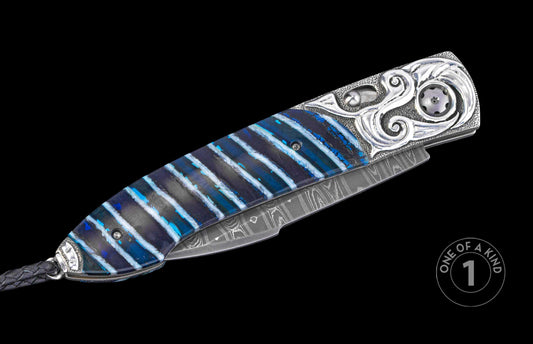 closed knife with mammoth tooth handle and hand carved designs on a black background