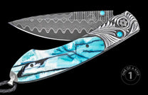Damascus steel folding knife with turquoise resin handle and intricate silver bolster, by W.H. Custom, featuring wave-pattern blade and gemstone accents, side view.